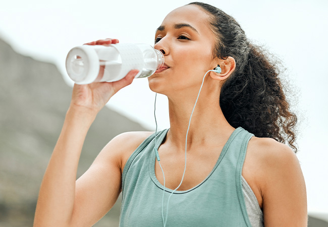 a woman drinking from a water bottle after losing weight with semaglutide in Fairfax, VA